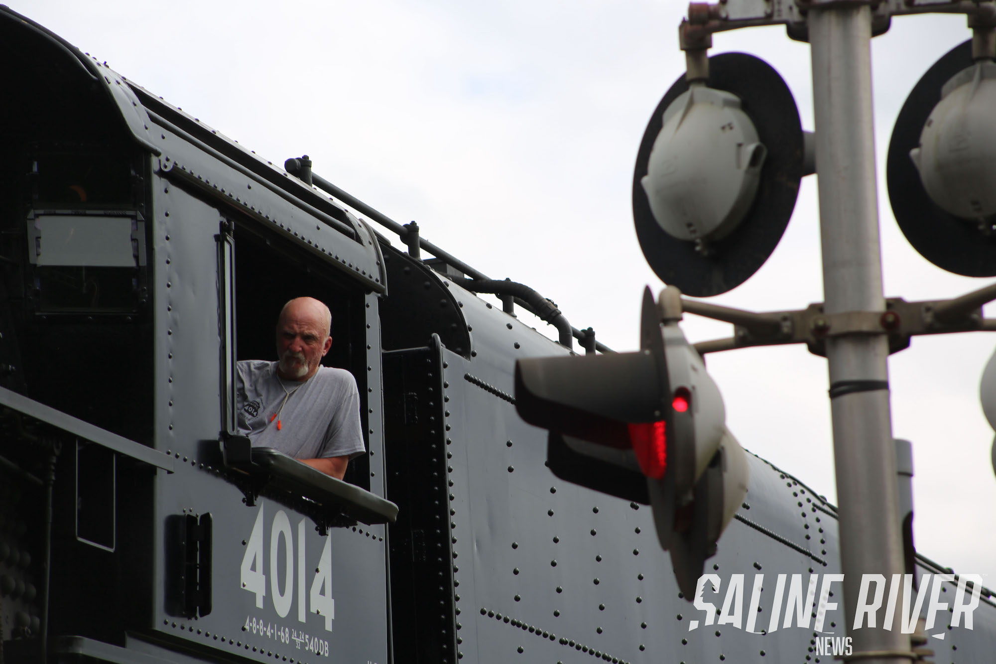 A man standing on the side of a train.