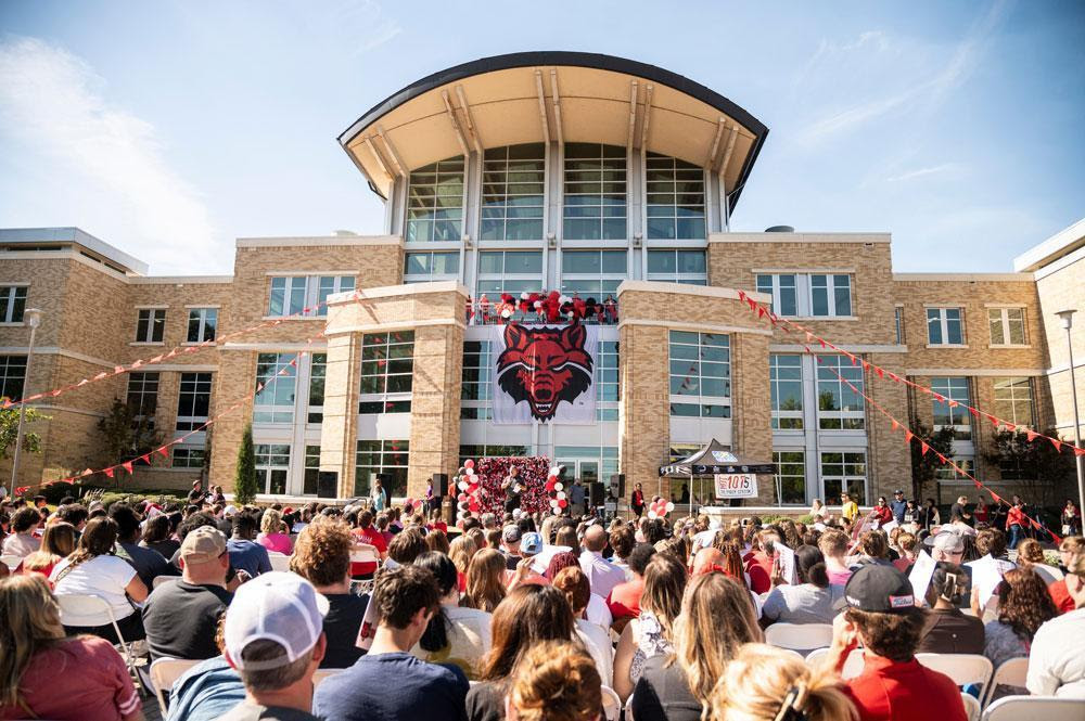 A large crowd of people gathered outside a building.