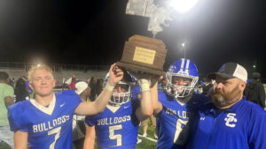A group of men holding up a trophy.