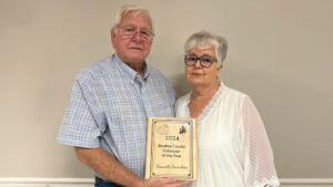 A man and woman holding a plaque