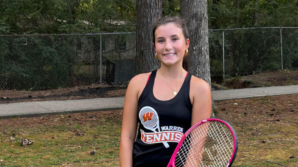 A girl holding a tennis racket in her hand.