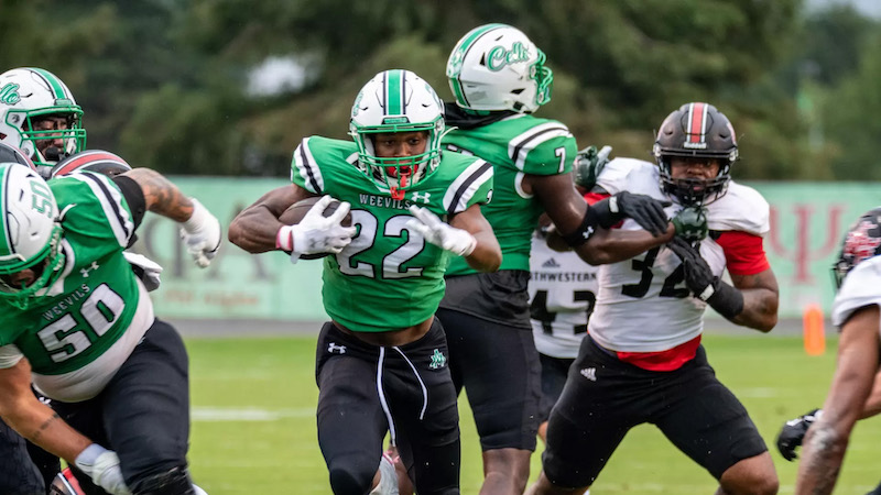 A group of football players running on the field.