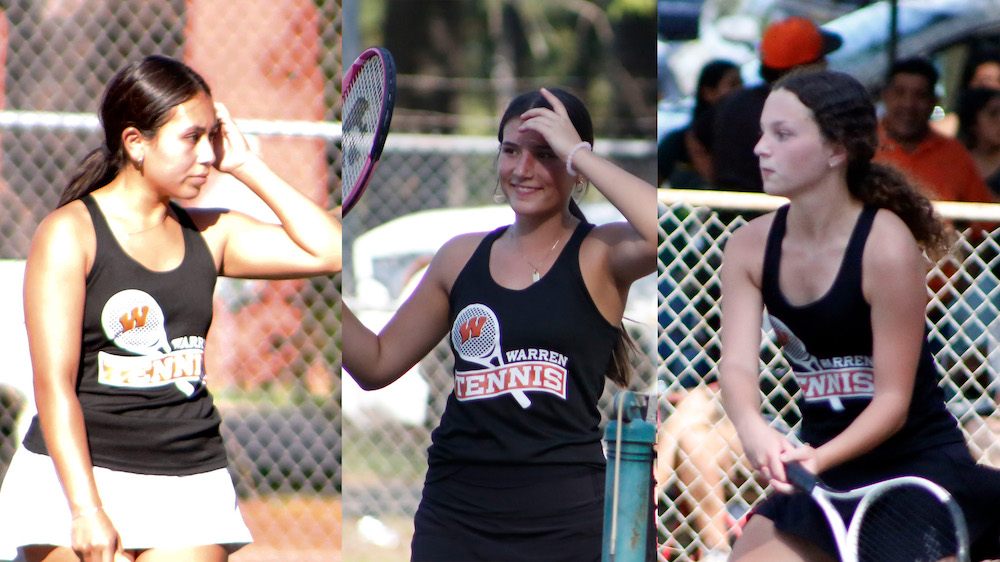 Three women playing tennis on a court.