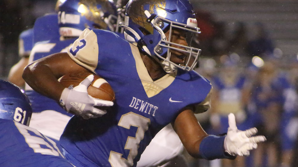 A football player running with the ball in his hand.