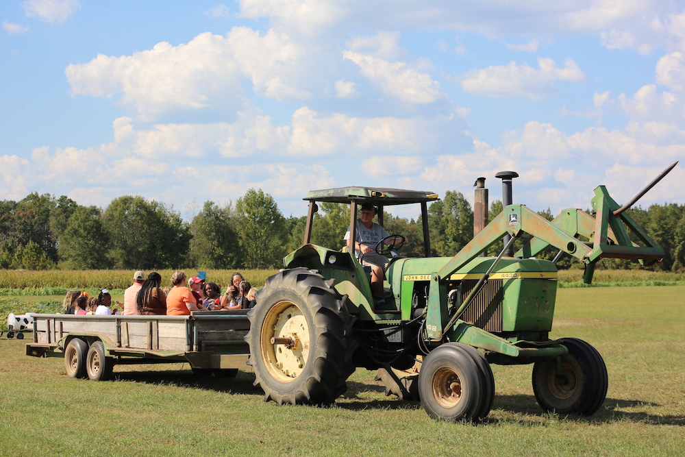 A tractor pulling a trailer full of people.