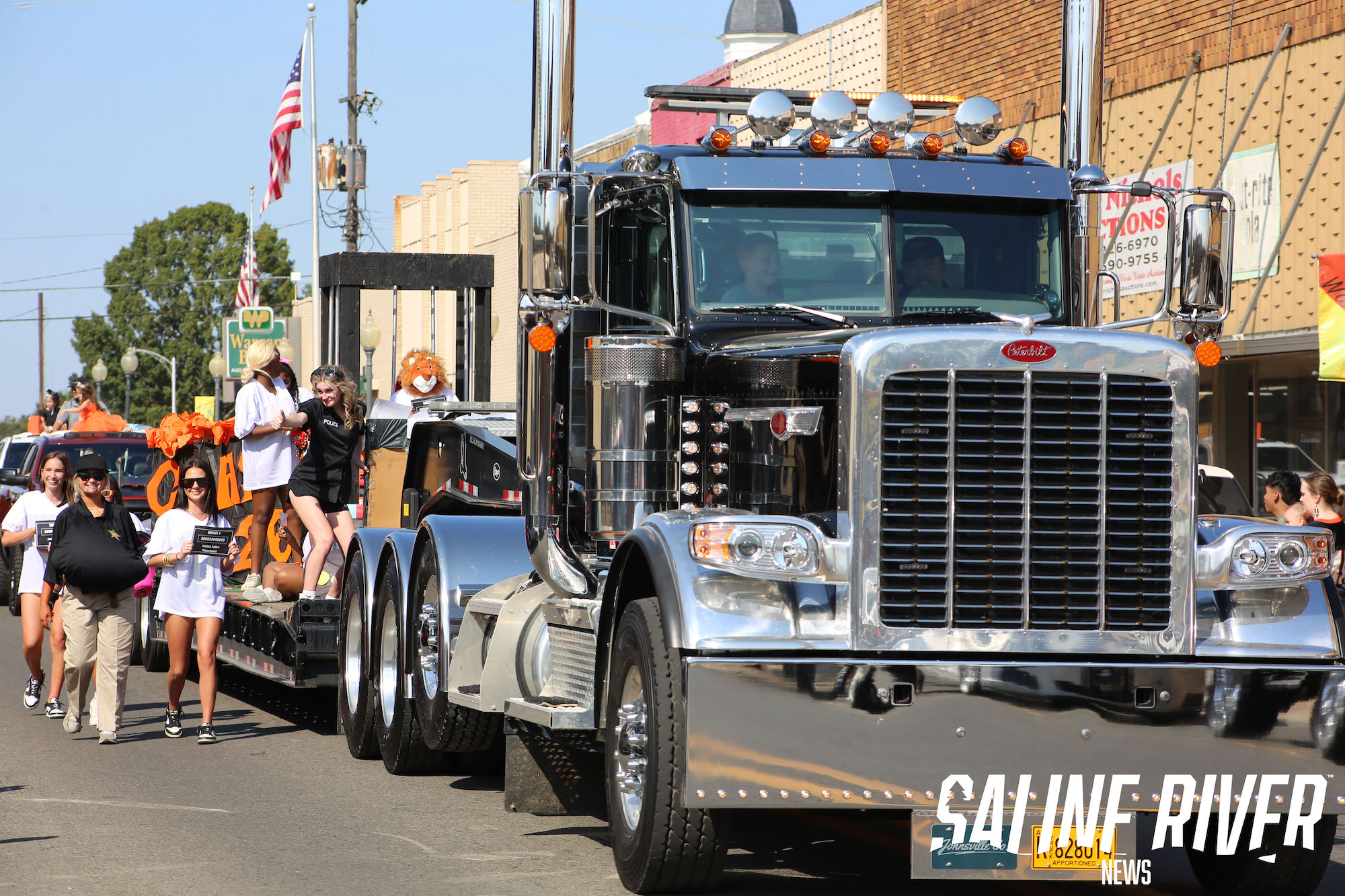 A large truck with people on it's back.