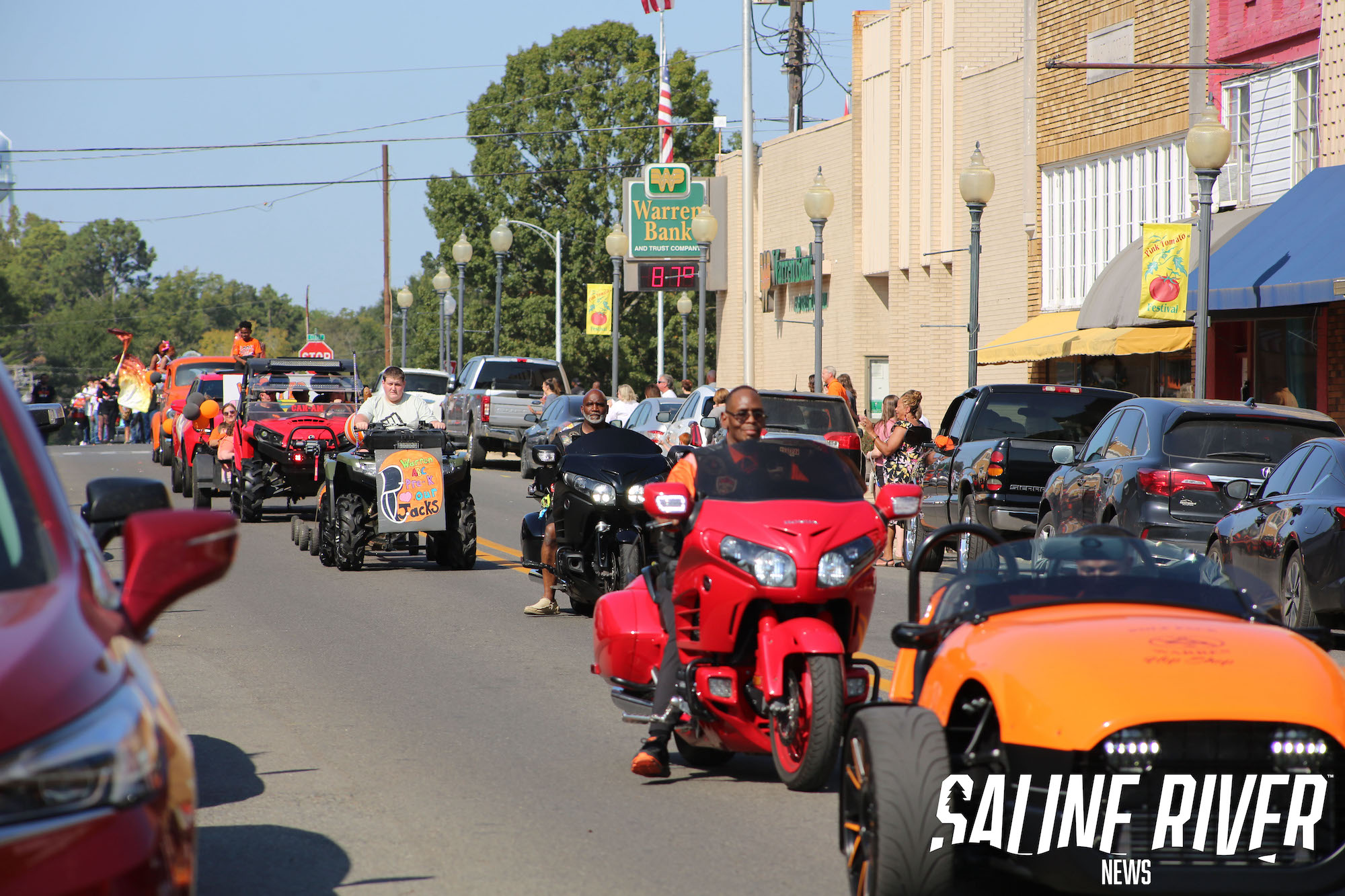 A group of motorcycles and cars driving down the street.