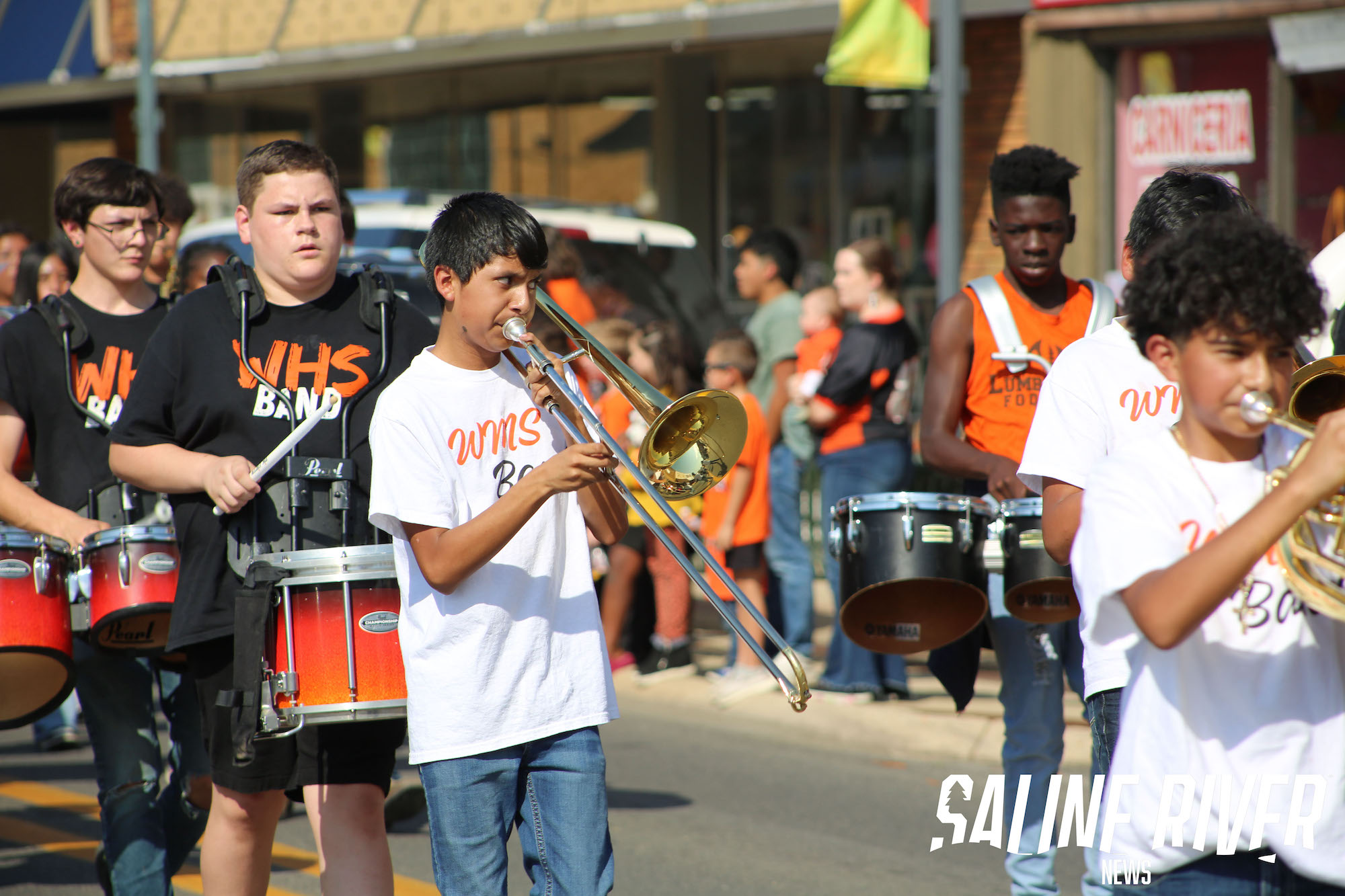 A group of people playing musical instruments on the street.