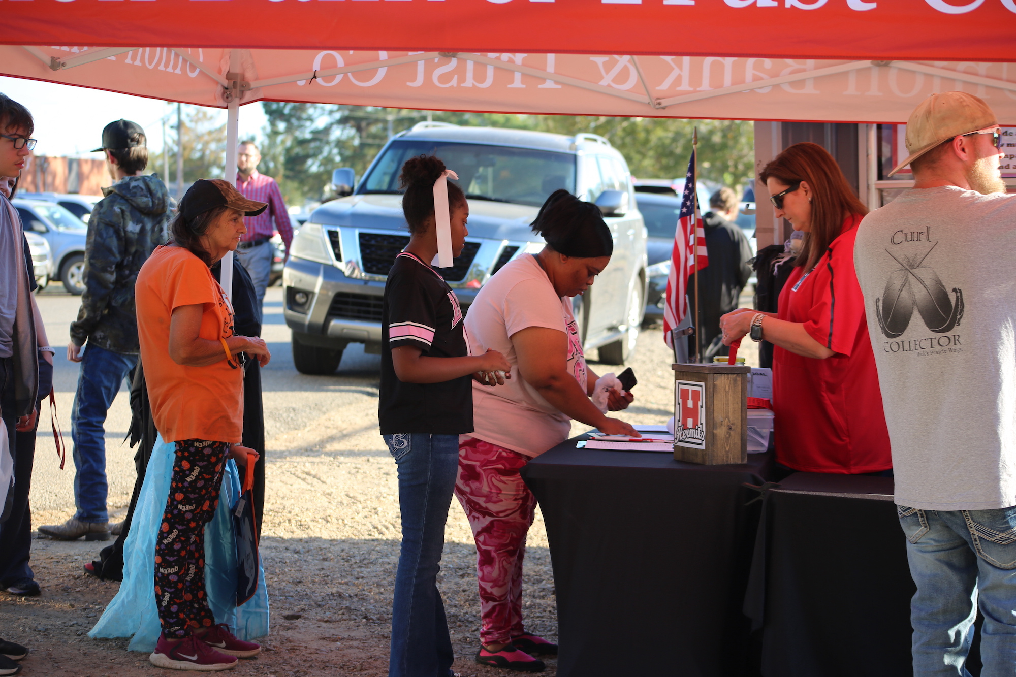 A group of people standing around an event tent.