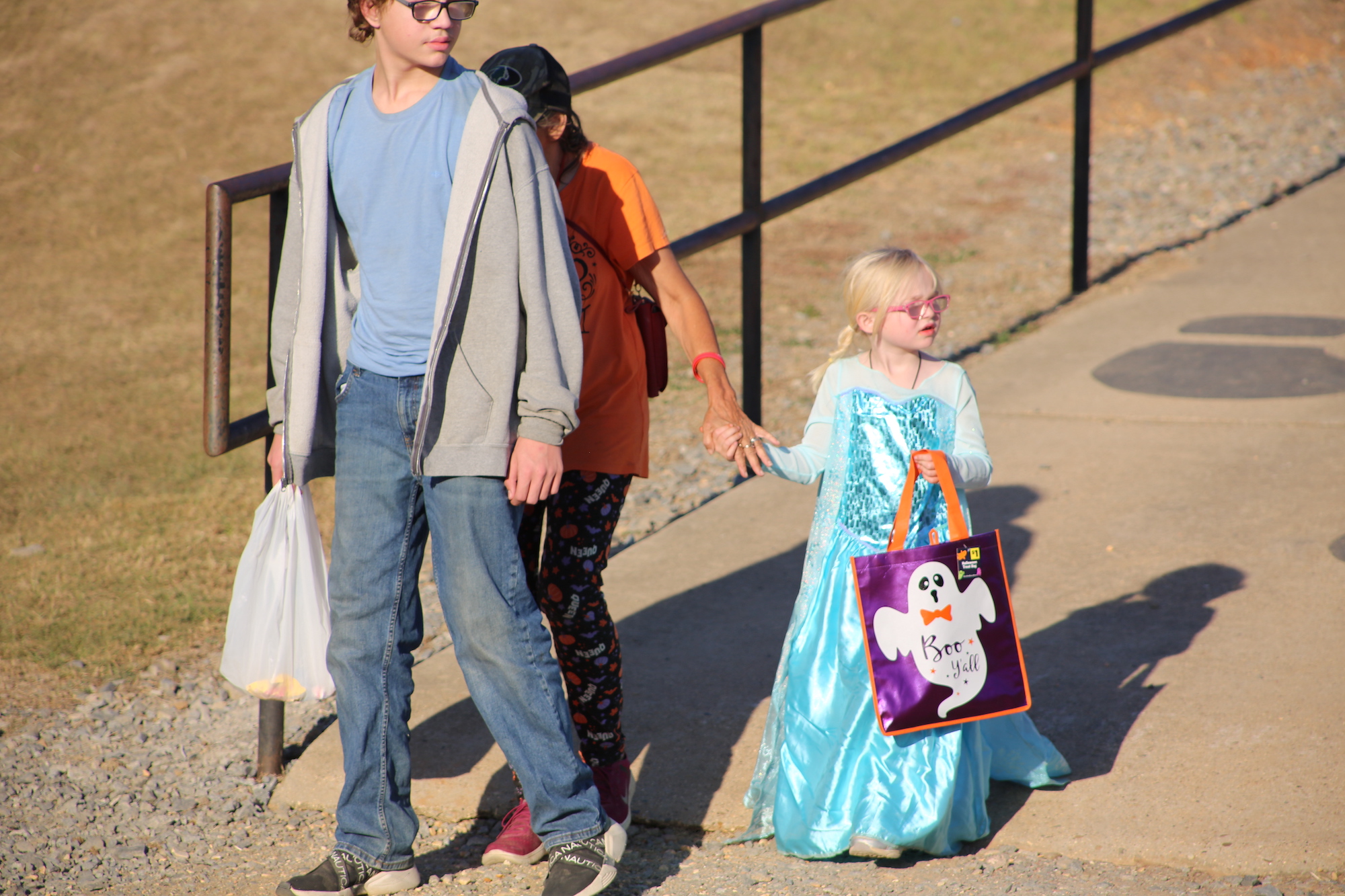 A young boy and girl walking down the street.
