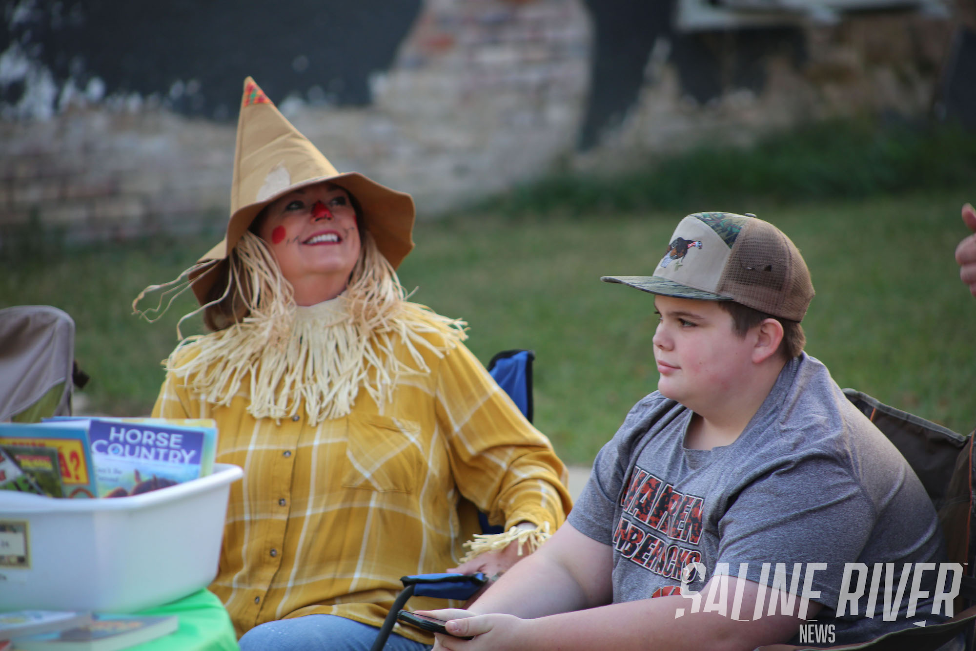 A woman and boy sitting on the grass.