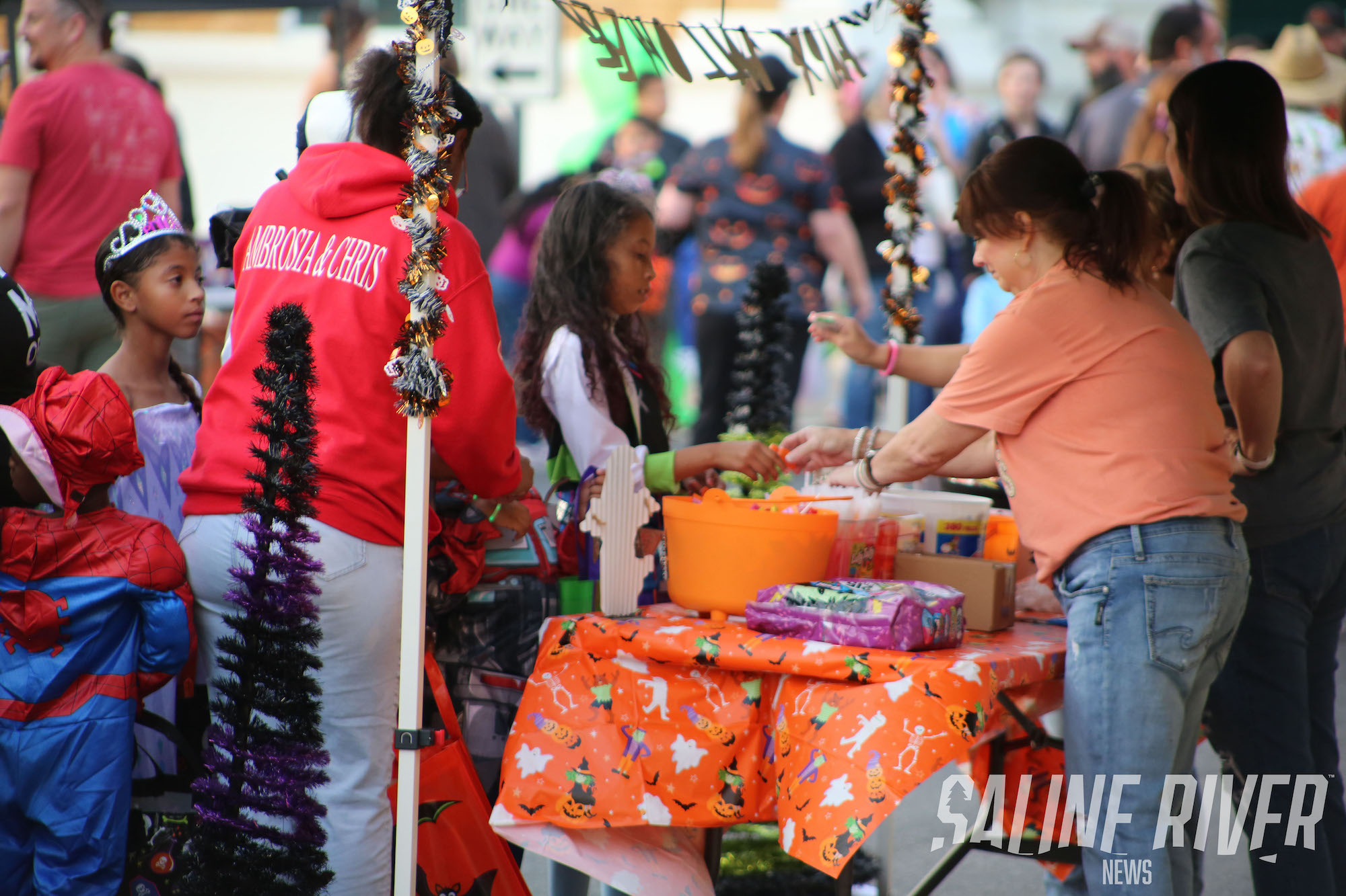 A woman is selling candy at an outdoor market.