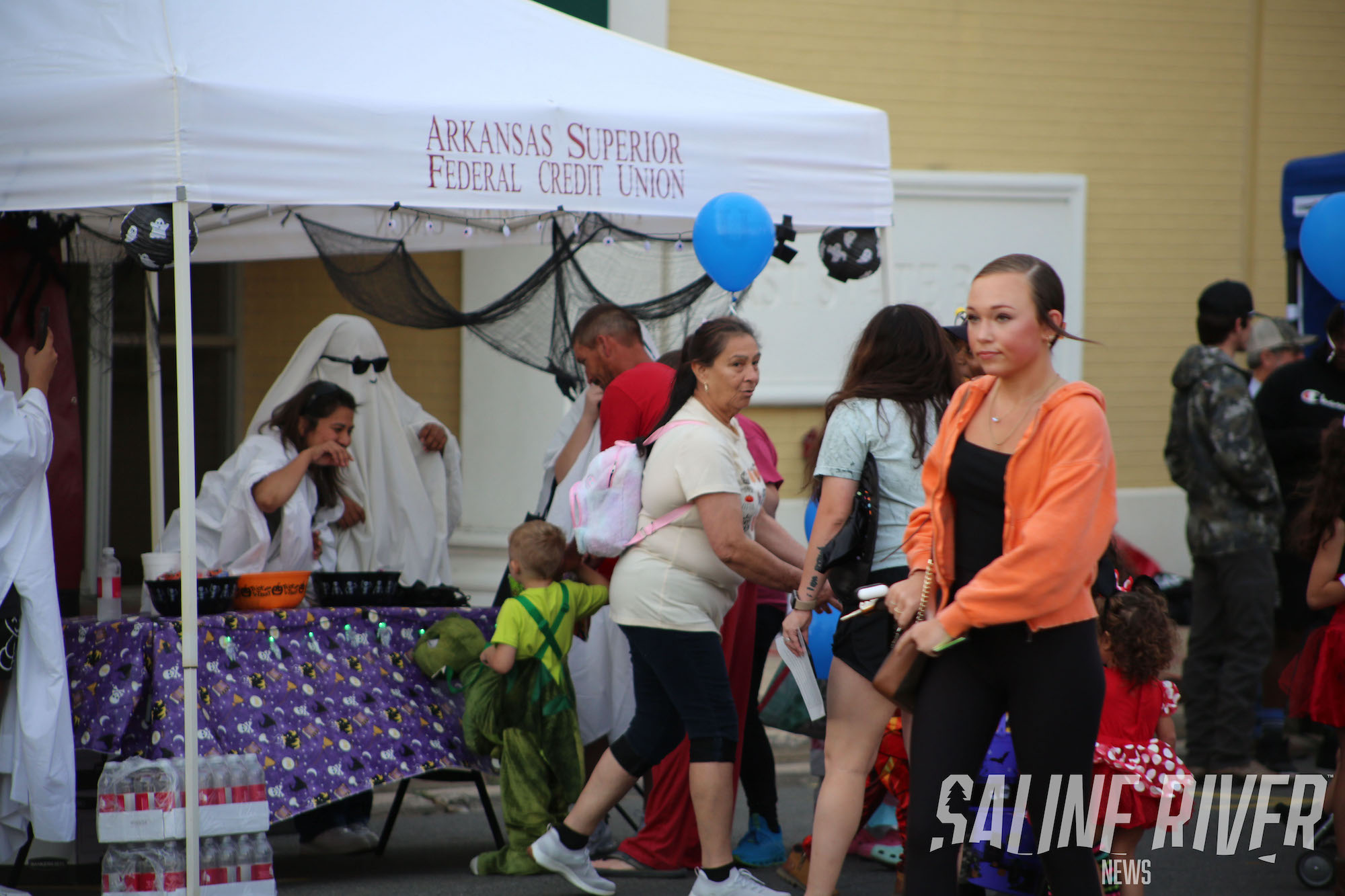 A group of people standing around an event tent.