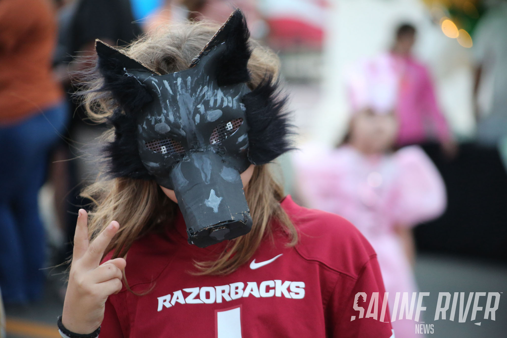 A person wearing a wolf mask and a razorback shirt.