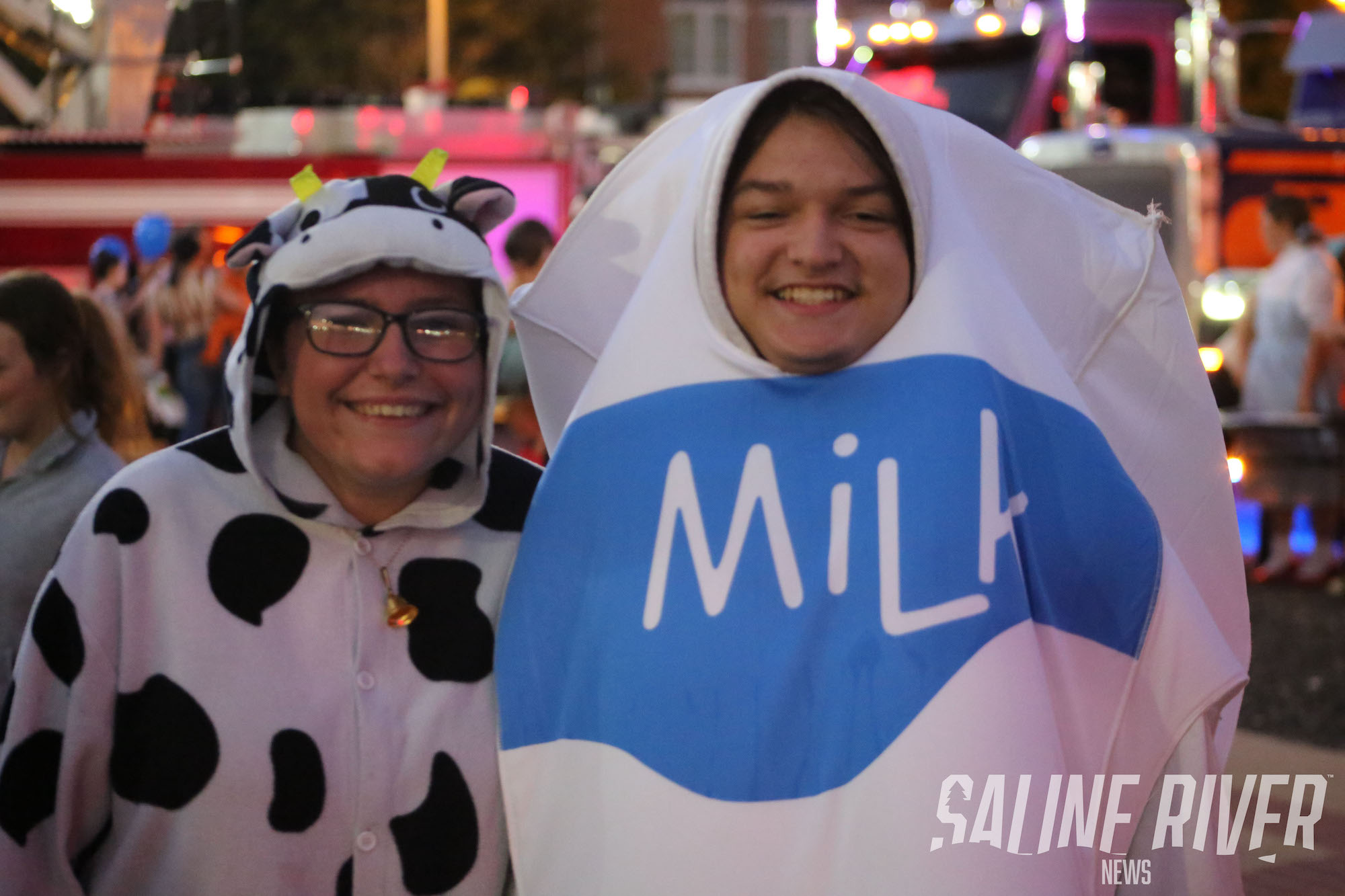 Two people dressed as milk and a cow