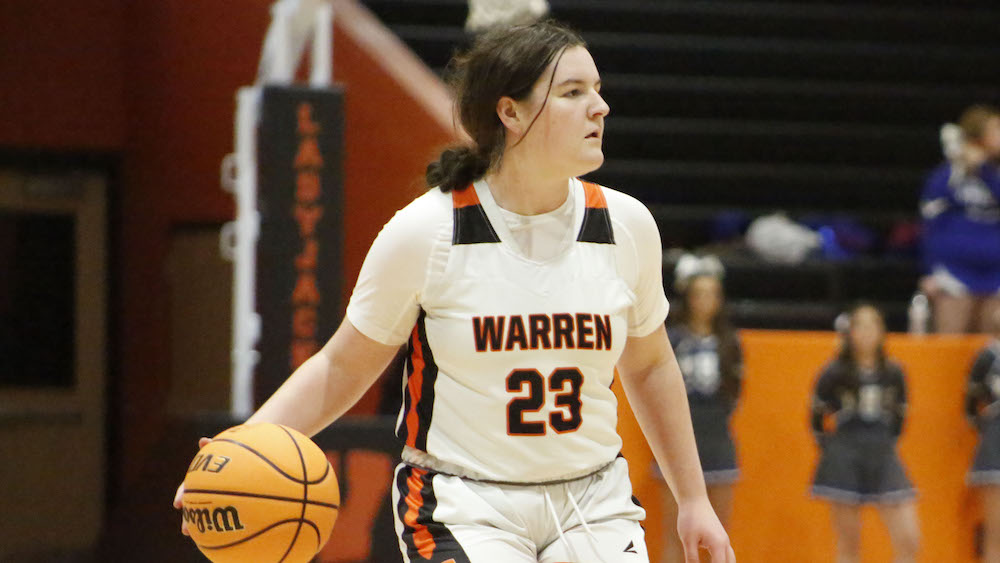 A woman holding onto a basketball in front of her.