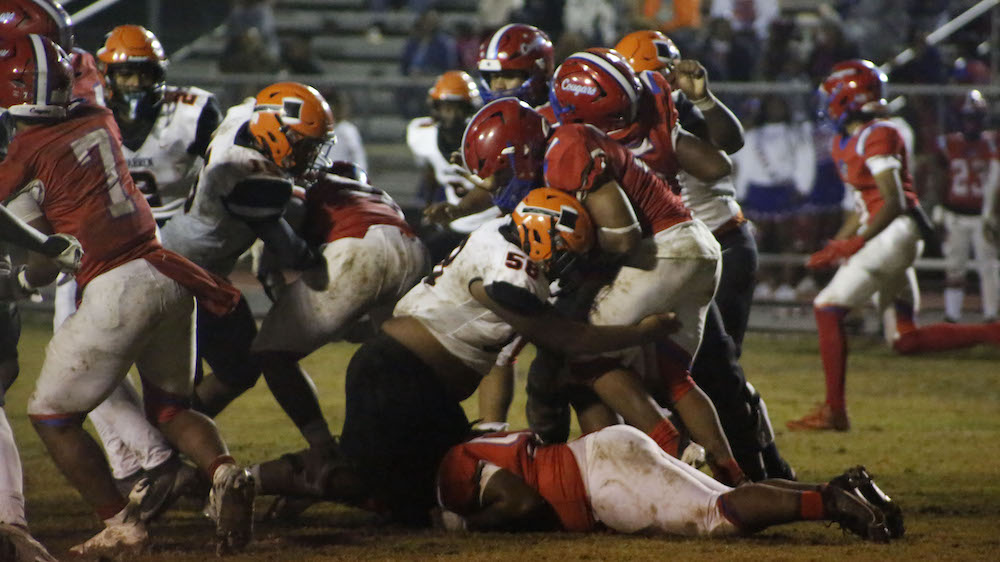 A group of football players are fighting for the ball.