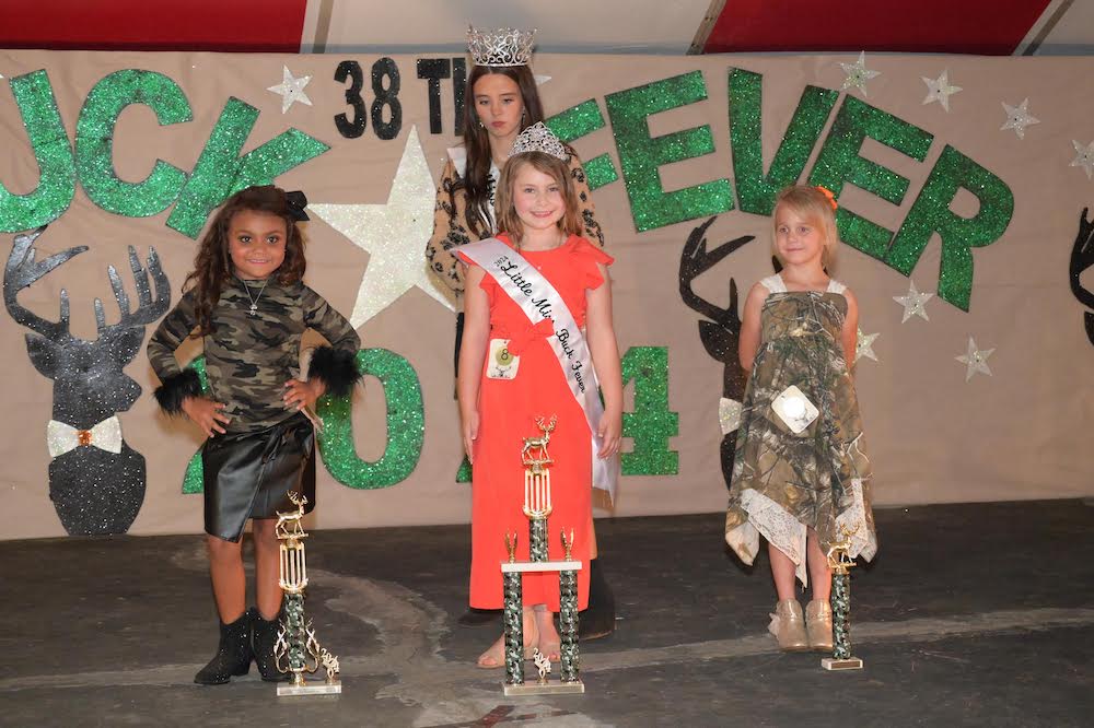 Three girls are posing for a picture on the stage.