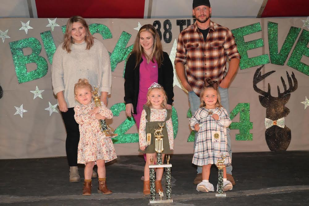 A group of people standing on stage with trophies.