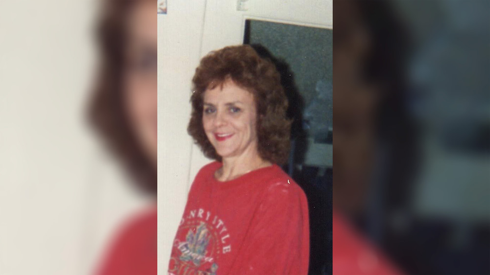 A woman in red shirt smiling for the camera.