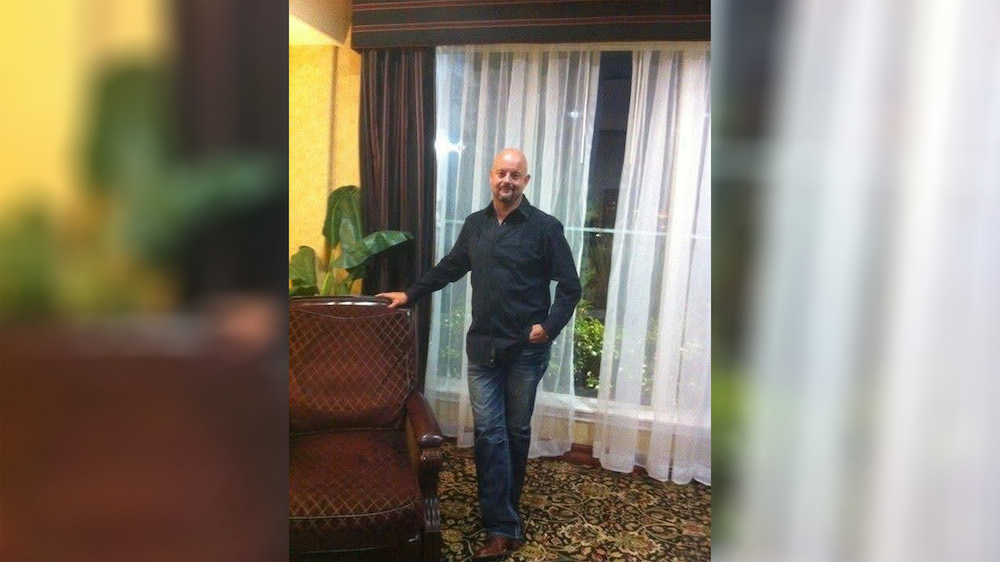 A man standing in front of a window.