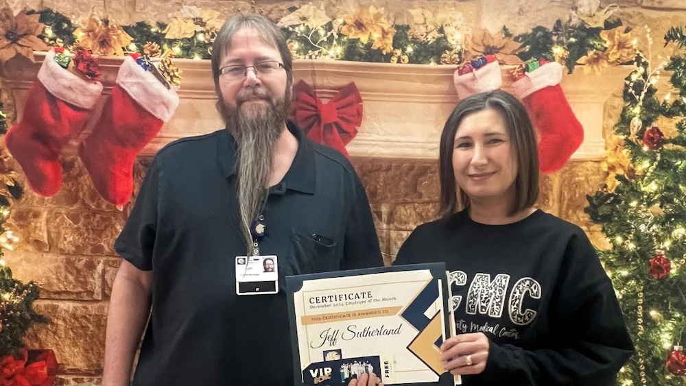 A man and woman holding up a certificate.
