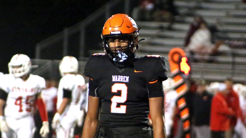 A football player in an orange helmet and uniform.