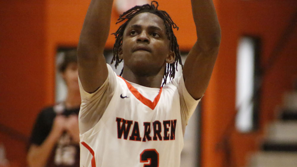 A person in a white and orange basketball uniform.