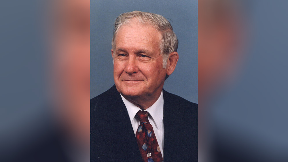A man in suit and tie smiling for the camera.