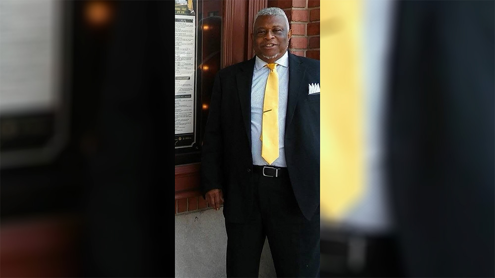 A man in a suit and tie standing outside.