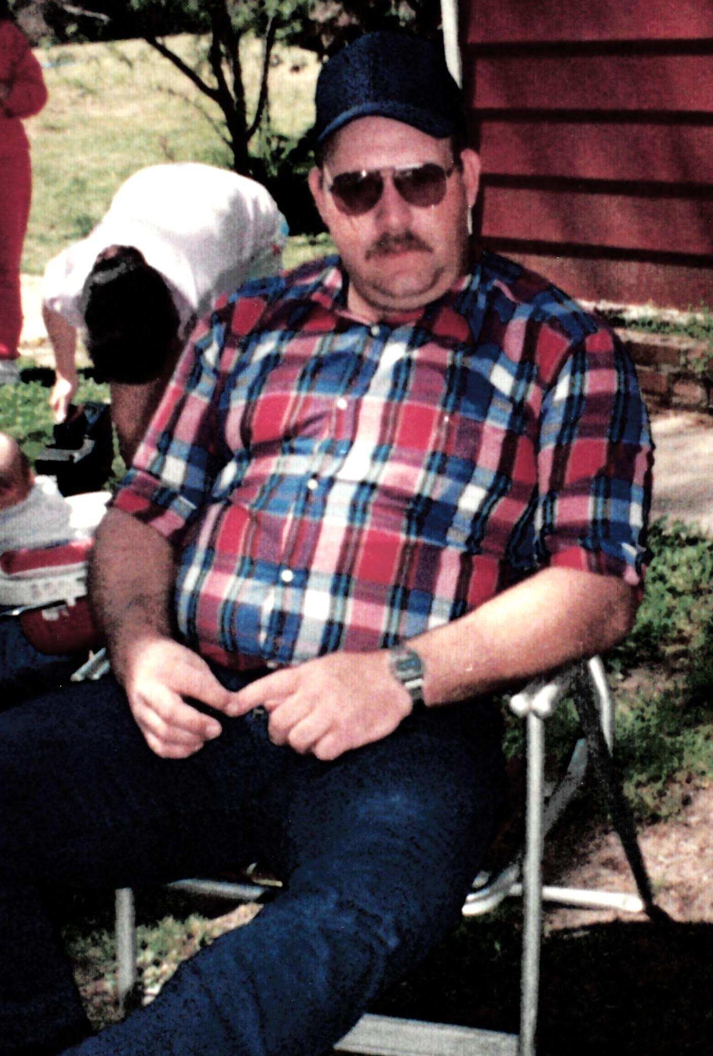 A man sitting in a chair wearing sunglasses.
