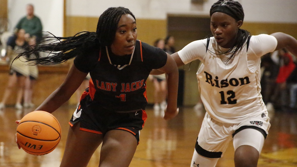 Two women playing basketball on a court