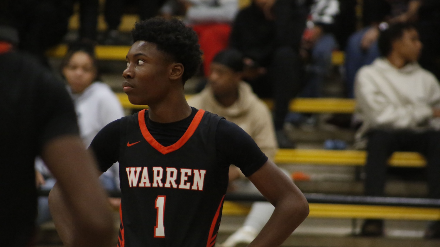 A young man standing on top of a basketball court.
