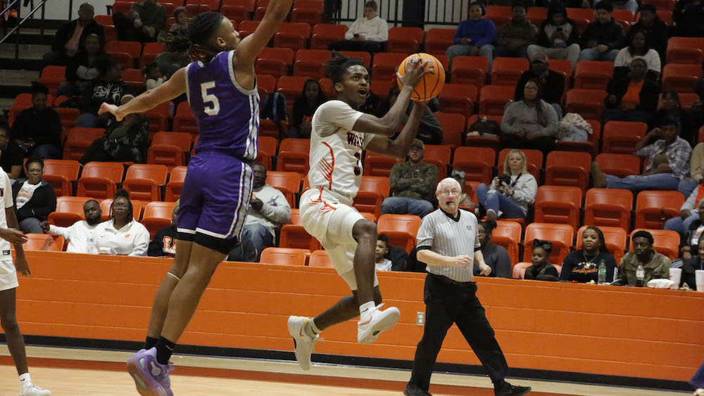A basketball player is going to the basket.