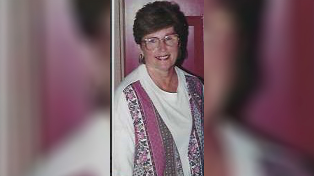 A woman wearing glasses and a white shirt.
