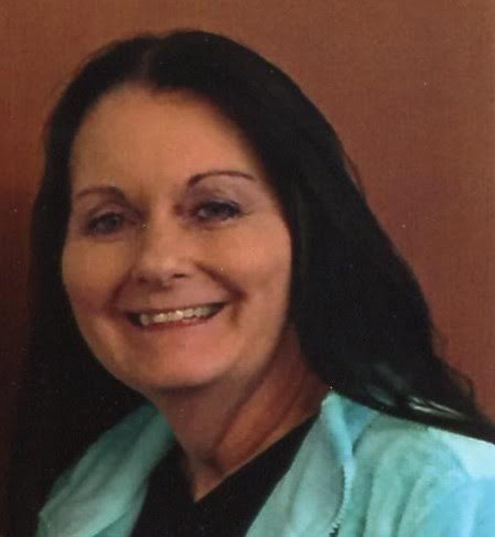 A woman with long black hair wearing a blue shirt.