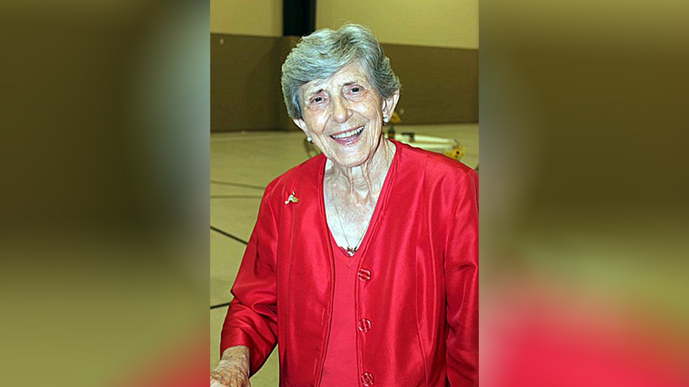 A woman in red jacket smiling for the camera.