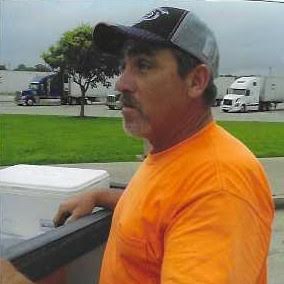 A man in an orange shirt and hat.