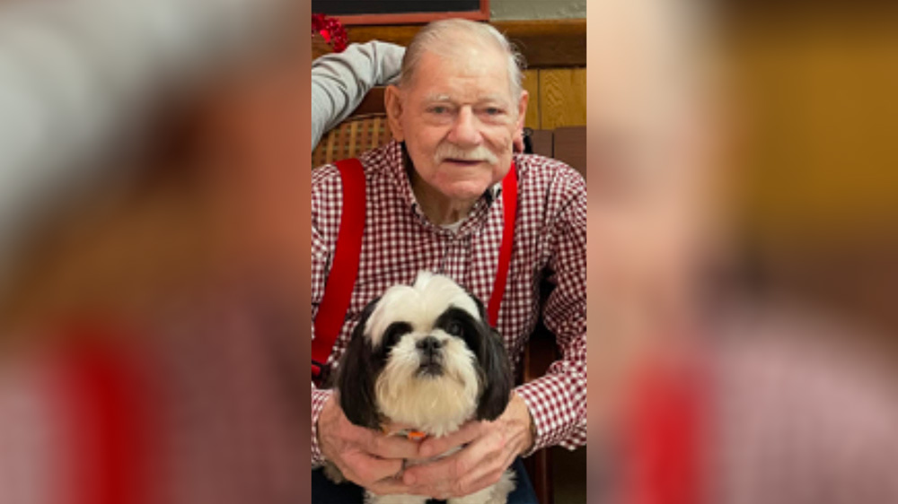 A man holding his dog in his lap.