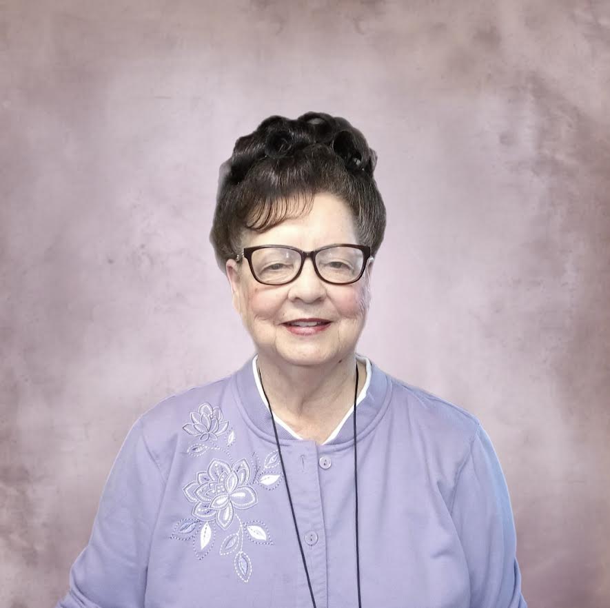 A woman with glasses and a purple shirt