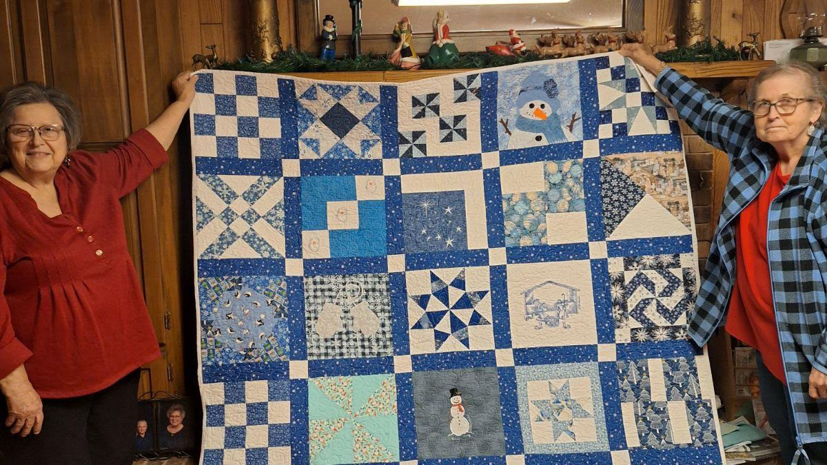 A blue quilt with different designs on it.