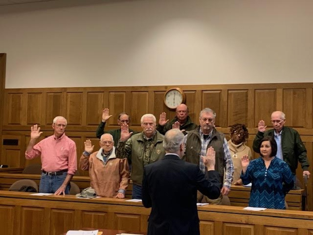 A group of people standing in front of a judge.