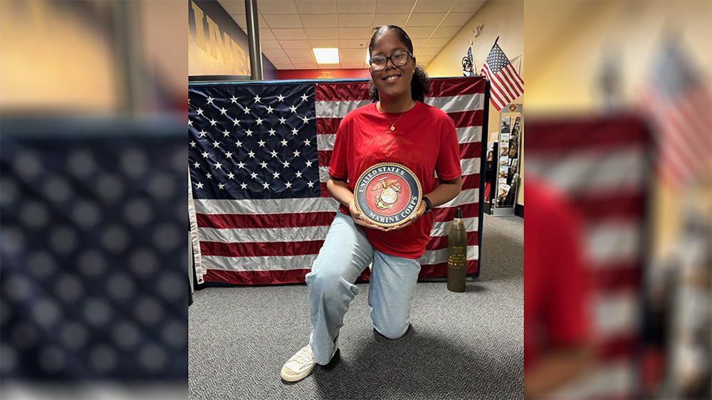 A woman kneeling down holding an american flag plate.