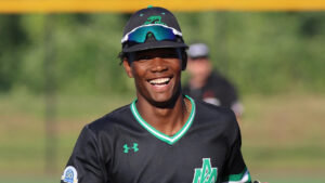 A baseball player smiles while wearing a helmet.