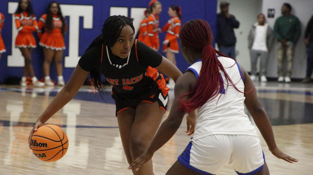 Two women playing basketball on a court