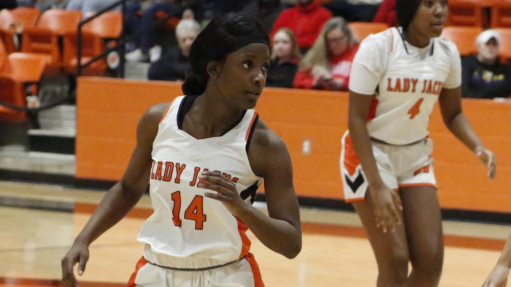 A woman in white and orange basketball uniform.