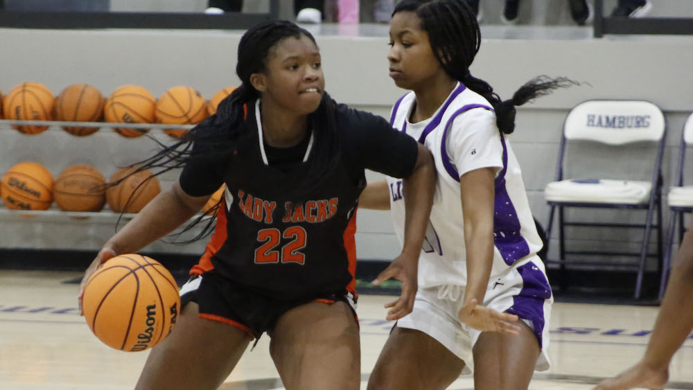 Two girls playing basketball on a court
