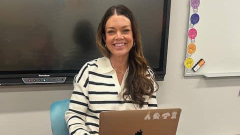 A woman sitting in front of a laptop computer.
