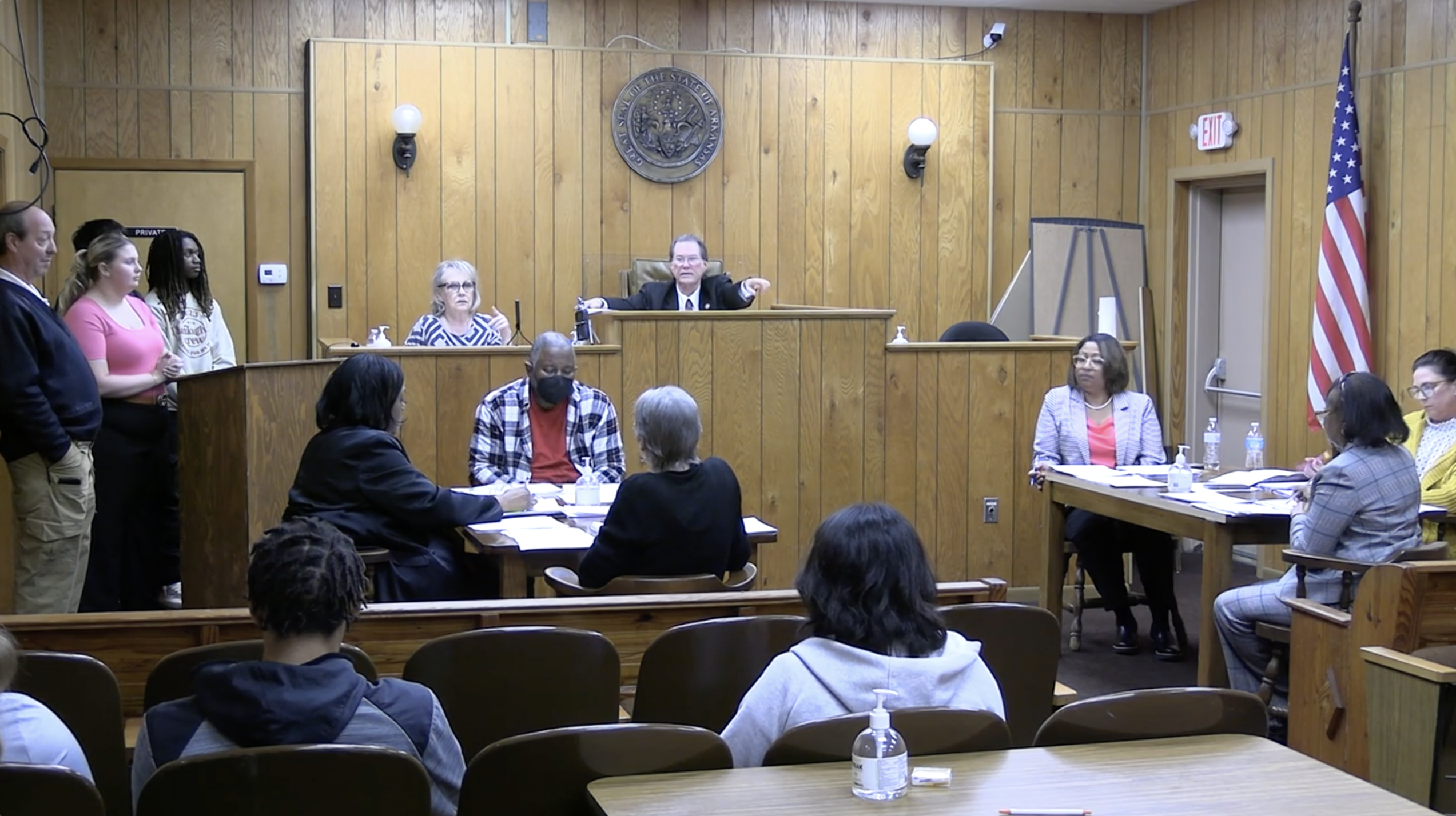 A group of people sitting in front of a judge.