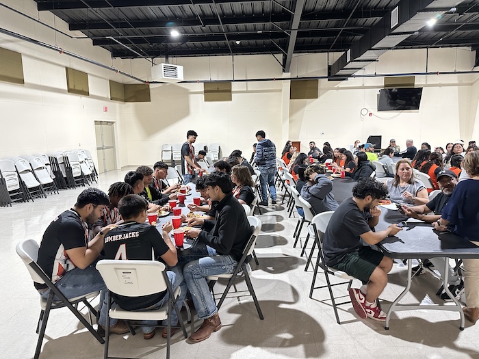 A group of people sitting at tables eating food.
